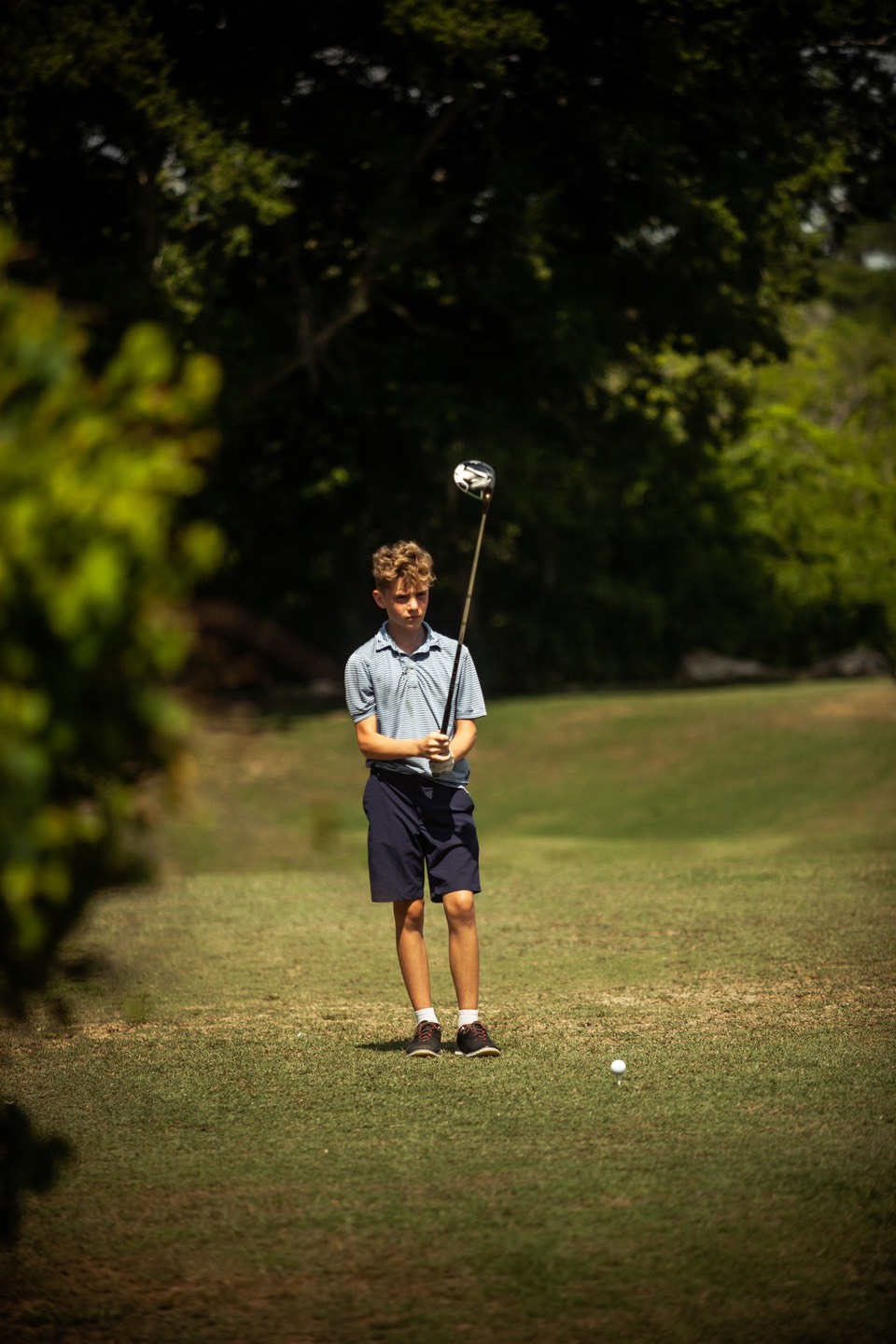 Junior golfer following through on a tee shot